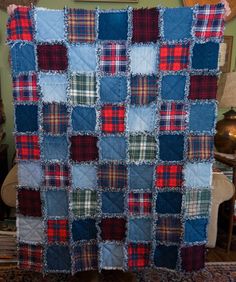 a blue and red plaid quilt hanging on a wall next to a chair in a living room