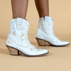 She wears flowers in her hair and flowers on her boots. The Primrose is Dingo1969's take on boho vibes. Soft wearable leather, pretty embroidered flowers and lacing detail make the #Primrose ready for the garden party, the festival and nights on Lower Broadway. Kick your style up a notch. #beautyandtheboot Spring Embroidered White Boots, Spring White Embroidered Boots, Floral Embroidery Boots For Spring Festival, Floral Embroidered Boots For Spring Festival, Bohemian Floral Print Round Toe Boots, Bohemian Round Toe Boots With Floral Print, Spring Festival Embroidered Boots, Embroidered Boots For Spring Festivals, Vintage Ankle Boots For Spring