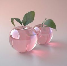 two shiny pink apples with green leaves in them