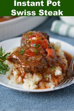 a white plate topped with mashed potatoes covered in gravy and meat sauce