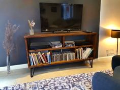 a living room with a large television on top of a wooden entertainment center next to a blue couch