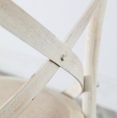 the back of a white chair with wooden slats on it's armrests