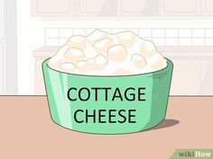 a green bowl filled with cottage cheese on top of a table