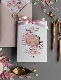 wedding stationery with pink flowers and gold foil on the front, along with matching envelopes