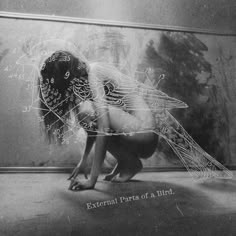 a woman kneeling on the ground in front of a wall with an image of a bird