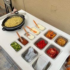 a table topped with lots of food and containers filled with different types of toppings