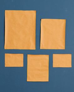 four pieces of yellow paper laid out on a blue surface