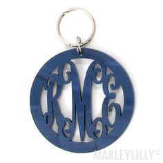 a round metal keychain with the letter m in it's center and an initial