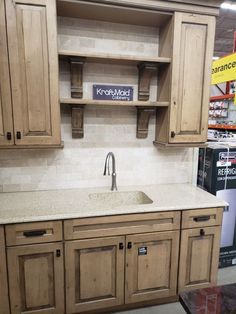 a kitchen with wooden cabinets and a white counter top in a store or showroom