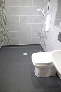 a white toilet sitting next to a walk in shower