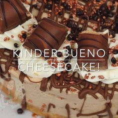 a close up of a cake with chocolates and nuts on the top that says kinder buenoo cheesecake