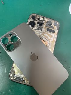 an apple iphone is sitting on top of a broken keyboard and some other parts are laying next to it