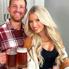 a man and woman sitting at a table with beer