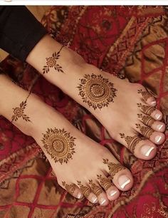 two feet with henna tattoos on them