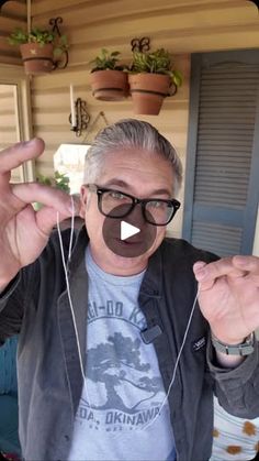 a man wearing glasses and listening to headphones with his fingers in front of him