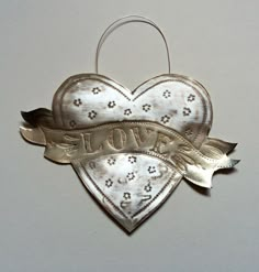 an ornament shaped like a heart with the word love on it