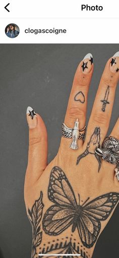 a person's hand with tattoos on it and a butterfly tattoo on the middle finger