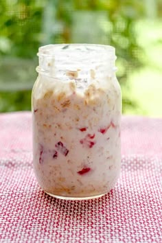 a jar filled with oatmeal sitting on top of a red and white checkered table cloth