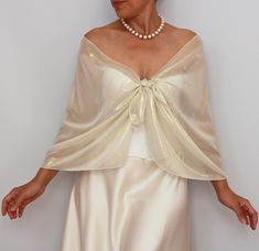 This shiny Metallic Beige Cream Chiffon Wedding Shawl Wrap is the perfect addition to your bridal party's attire. This beautiful bridesmaid dress topper cover-up scarf adds an elegant touch and a hint of glamour to any ensemble, making it an essential accessory for your special day. Crafted from premium-quality, cream silky soft chiffon fabric with shiny gold metallic effect, this wedding shawl wrap boasts a delicate and luxurious texture that drapes gracefully over the shoulders. The metallic c Elegant Beige Formal Shawl, Fitted Wedding Shawl Wrap, Elegant Sheer Shawl For Wedding, Elegant Sheer Wedding Shawl, Elegant Cream Shawl For Evening, Cream Silk Shawl For Wedding, Elegant Wedding Wrap, Elegant Silk Wraps For Wedding, Elegant Silk Wedding Wrap