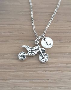 a silver necklace with a motorcycle charm on it