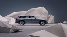 a grey car parked in front of some white rocks and cement structures on the ground