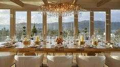 a dining room table with chairs and a chandelier hanging from it's ceiling