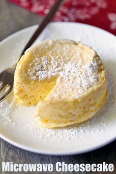 a white plate topped with a piece of cake covered in powdered sugar next to a fork