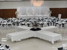 tables and chairs are set up in an empty room with black and white linens