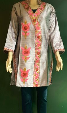 Embroidered Tunic Crafted from raw Silk, designed in Classic Kashmiri Aari embroidery.  Match it with a pair of denims or leggings perfect for Women and Girls a classic tunic that never goes out of fashion. ThisTunic features intricate  embroidery on the neckline, sleeves, the side hem and motif on the front. A combination of vibrant shades with a beautiful play of colors. Color: silk Pink -Color can vary due to lighting. All sizes  are approx.  Size: USA, M  Chest:38 inch.  Shoulder: 17 inch.  Sleeve length: 18 inch  Length: 33 inch. Fabric: Raw Silk- Dry clean or hand wash, iron on low heat. Made in a smoke and pet free home. Made in Kashmir, India Multicolor Floral Embroidered Blouse Piece For Navratri, Folk Style Tunic Embroidered Dress, Folk Style Embroidered Tunic Dress, Bollywood Style Multicolor Embroidered Top For Navratri, Festive Spring Blouse Piece, Traditional Embroidered Raw Silk Dress, Traditional Raw Silk Embroidered Dress, Bohemian Tops With Intricate Embroidery For Navratri, Traditional Festive Embroidered Tunic Dress