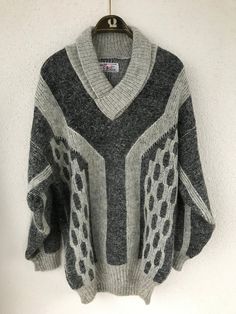 "Very warm men's patterned jumper in several shades of grey. It has a V-neck with flaps and a fold-over collar. The yarns are very warm with a fluffy finish.  Material: no composition of the sweater, it seems to be mohair wool. Size: the jumper seems to be best suited for those wearing size L - Large.. Also check out the measurements below: Shoulder: 59.5 cm - 23.42 inches Armpit to armpit 57 cm - 22.44 inches Total length 78 cm - 30.70\" Sleeve length from armpit: 53 cm - 20.86\" CONDITION: Very good vintage condition.  All measurements are taken with the garment lying flat. Due to lighting, the color of the product may be slightly different from the photos. Follow our store for new exclusive vintage clothing that's just for YOU! SHIPPING * I ship worldwide via Priority mail (Lietuvos Paš Gray Sweater For Cold Weather, Vintage Long Sleeve V-neck Sweater For Winter, Gray Jacquard Knit Winter Sweater, Gray Jacquard Knit Sweater For Winter, Gray Fair Isle Sweater For Fall, Gray Jacquard Knit Long Sleeve Sweater, Knitted Gray V-neck Sweater For Winter, Vintage Gray Sweater For Winter, Gray Knitted Sweater For Cold Weather