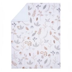 an image of a blanket with leaves and flowers printed on it in grey, gold and white