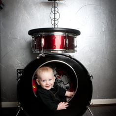 a baby sitting inside of a drum set