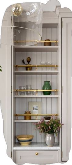 a white cabinet with gold trim and shelves filled with vases, plates and bowls