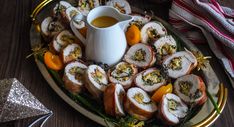 a platter filled with sliced up sushi and dipping sauce