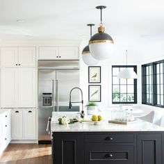 a kitchen with white cabinets and black island