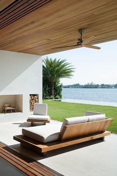 an outdoor living room with wood and white furniture