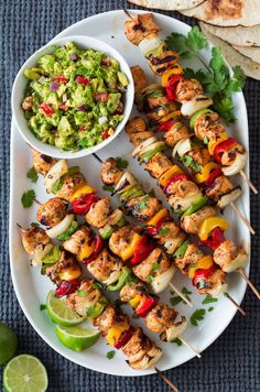 chicken kabobs on skewers with guacamole and salsa