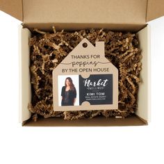 the open house box is filled with wood chips and has a tag that says thanks for popcorn by the open house