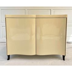 a cream colored cabinet with two doors on the front and one door open to reveal it's interior