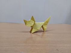 an origami cat sitting on top of a wooden table