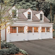 a two car garage with three windows on the top and one door open to let in light