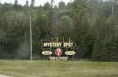 a sign that says mystery spot in front of some trees and grass with the words world famous on it