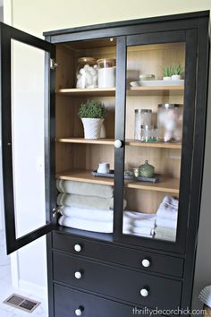 an open cabinet with towels and other items in it