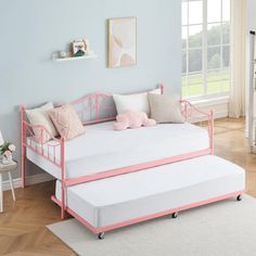 a day bed with pink metal frame and pillows