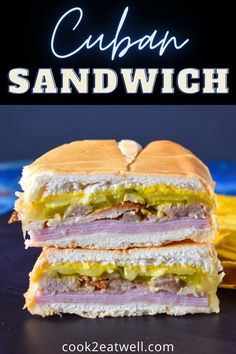 a sandwich cut in half on top of a blue plate with the words cuban sandwich