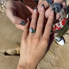 two hands holding onto each other with rings on their fingers and diamond bracelets around them