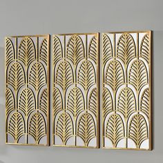 three gold art deco panels hanging on the wall