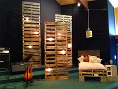 a bed made out of wooden pallets in a room with blue walls and green carpet