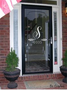 the front door is decorated with an american flag and monogrammed wreaths on it