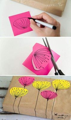 paper flowers are being cut out with scissors on top of a piece of brown paper